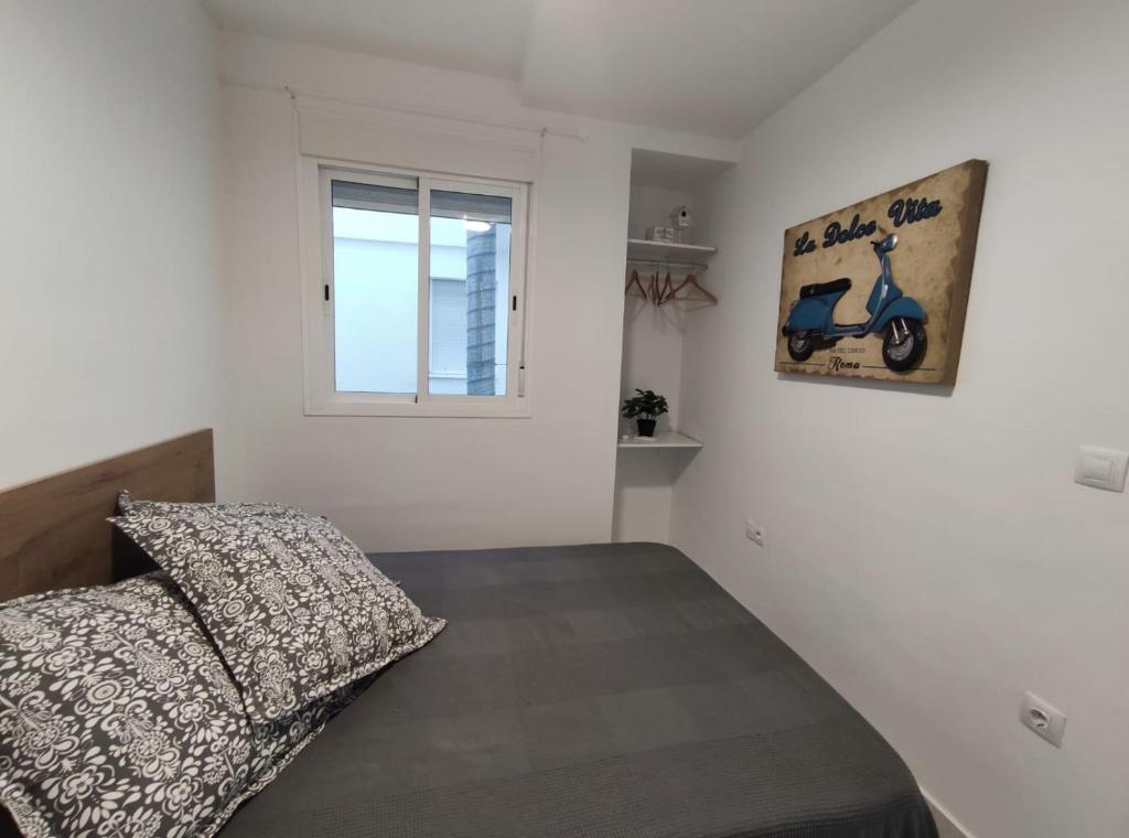 een slaapkamer met een bed en een raam bij Barrameda 19 in Sanlúcar de Barrameda