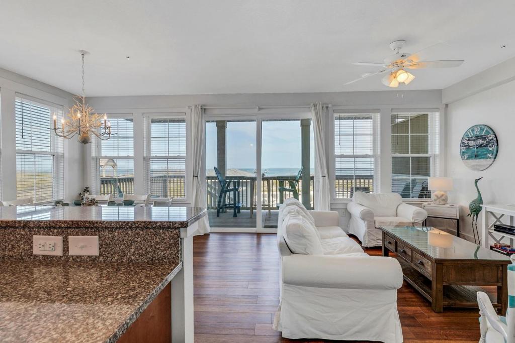 a kitchen and living room with a view of the ocean at SC202 Coastal LegaSea in Kill Devil Hills
