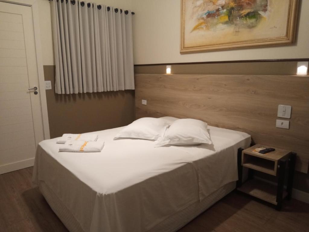 a bedroom with a bed with white sheets and pillows at Smart Hotel in Registro