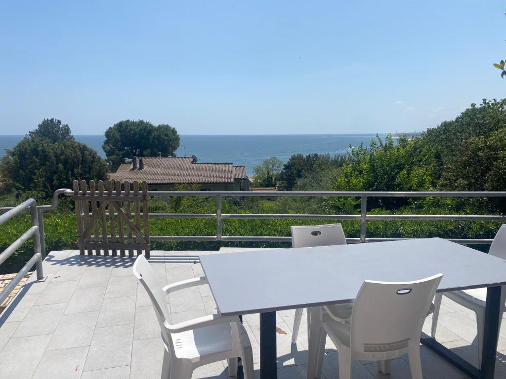 d'une table et de chaises blanches sur un balcon. dans l'établissement terrazza vista mare, giardino, parcheggio, wi fi, à Numana