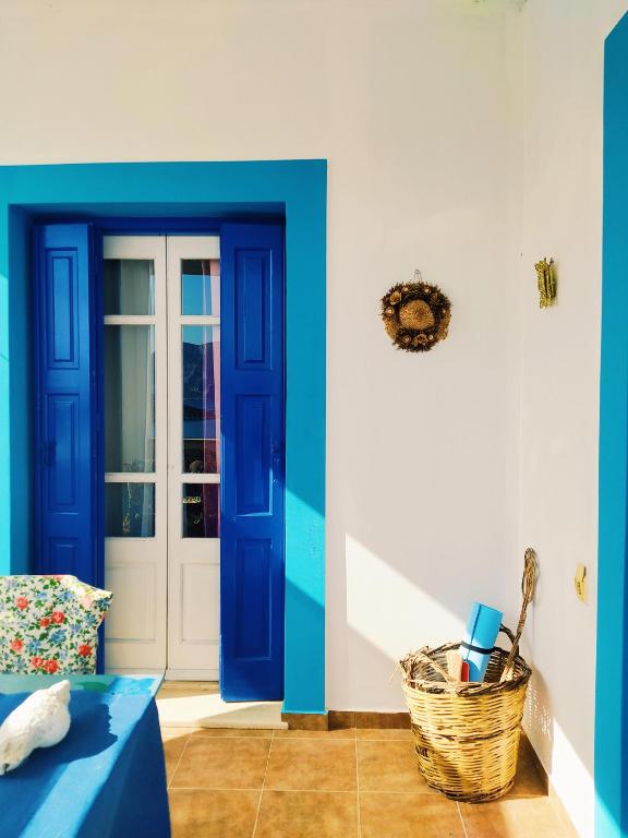 een kamer met een blauwe deur en een rieten mand bij Villa Irene in Kalymnos