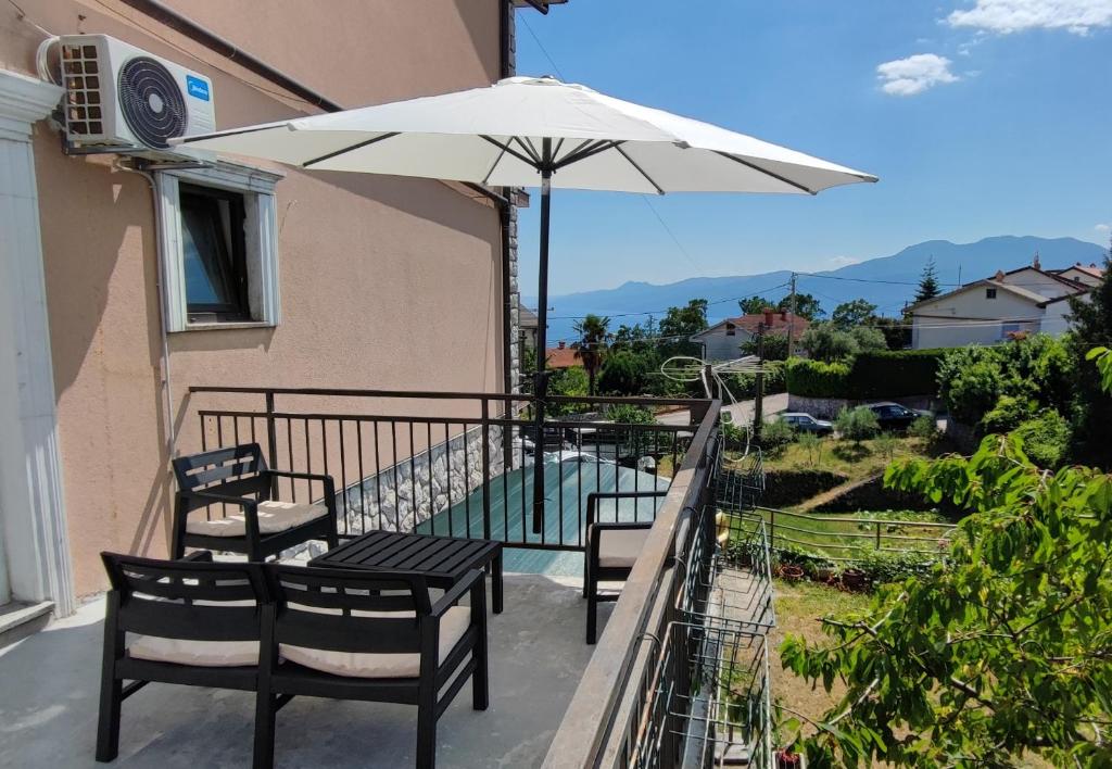 un patio avec une table, des chaises et un parasol dans l'établissement Smart home Sébastien, à Kastav