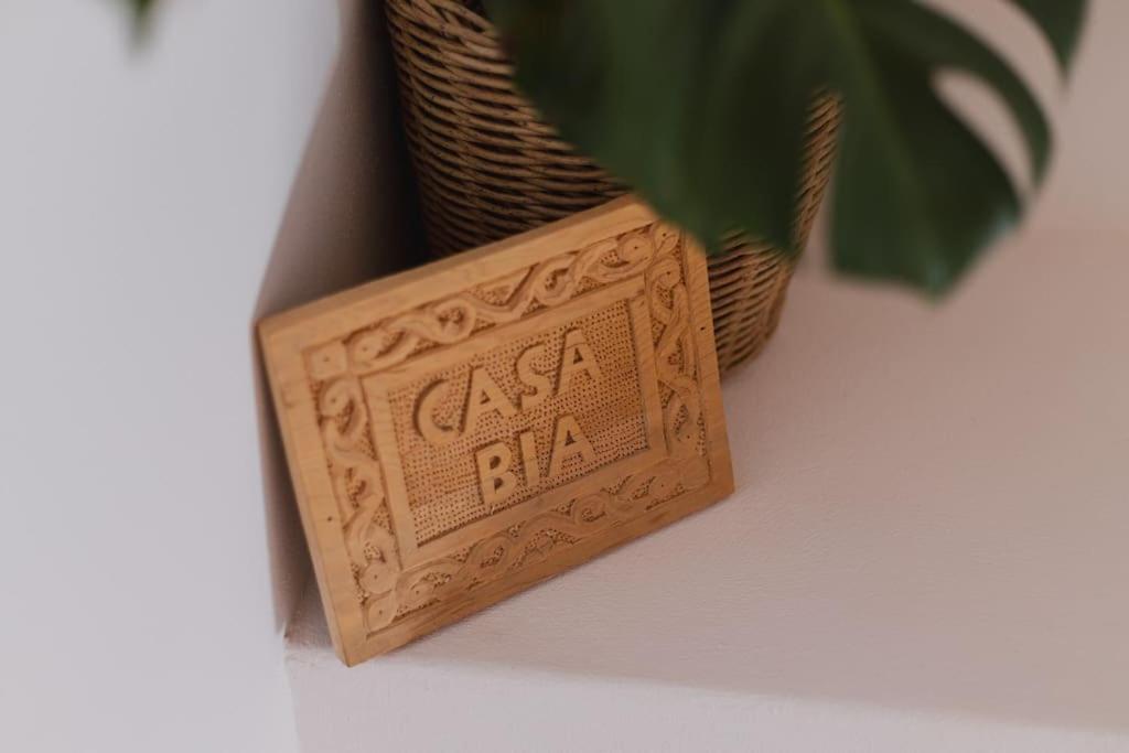 un bloc en bois avec les mots bar baiser assis à côté d'une plante dans l'établissement Casa Bia, à Lagos