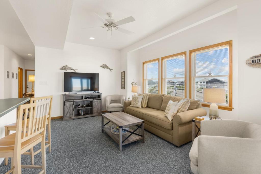 a living room with a couch and a tv at CR201 Salty Tides in Kill Devil Hills
