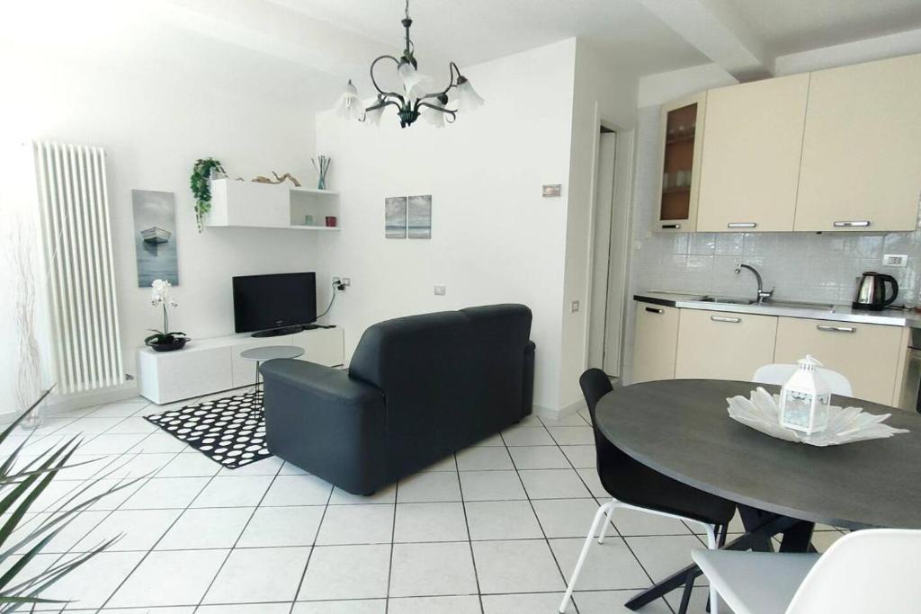 een woonkamer met een tafel en een keuken bij Casa Lety con giardino, aria condizionata e wifi in Rimini