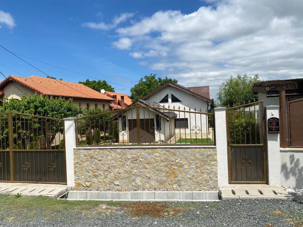 einen Zaun mit einer Steinmauer vor einem Haus in der Unterkunft Casa moderna in Mineri in Mineri