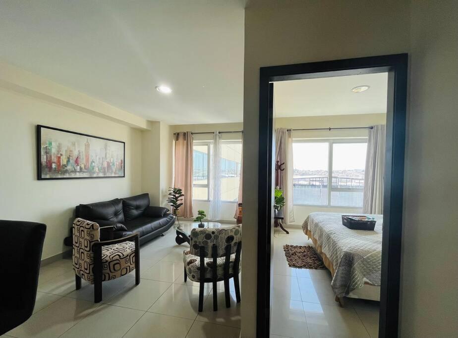 1 dormitorio con 1 cama y sala de estar con sofá en Coffee Suite, wifi, Parqueo, gym & piscina! en Guayaquil