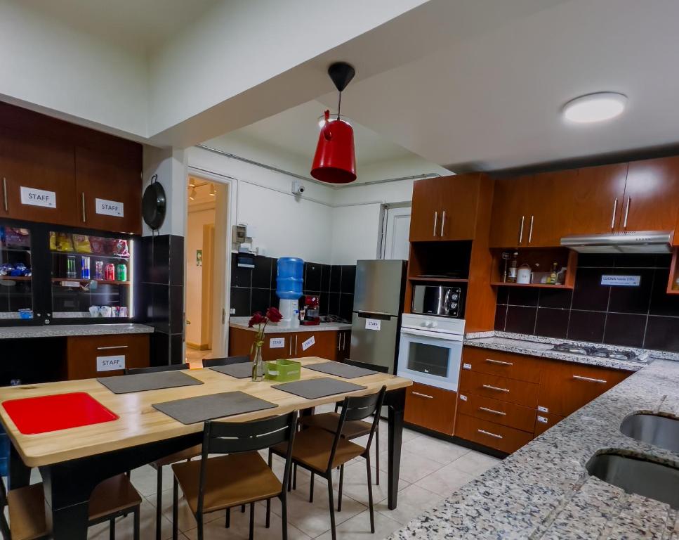 cocina con mesa de madera y sillas en Yogi hostel boutique, en Santiago