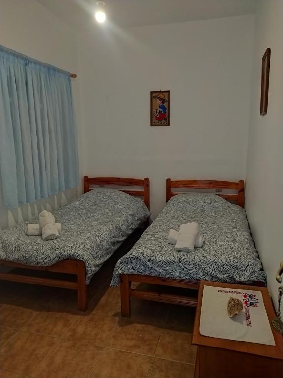 two twin beds in a room with a table at Villa Irene in Kalymnos