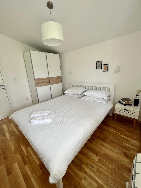 a bedroom with a large bed with white sheets at Divine House in Žabljak