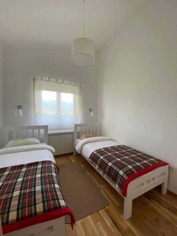 a bedroom with two beds and a window at Divine House in Žabljak