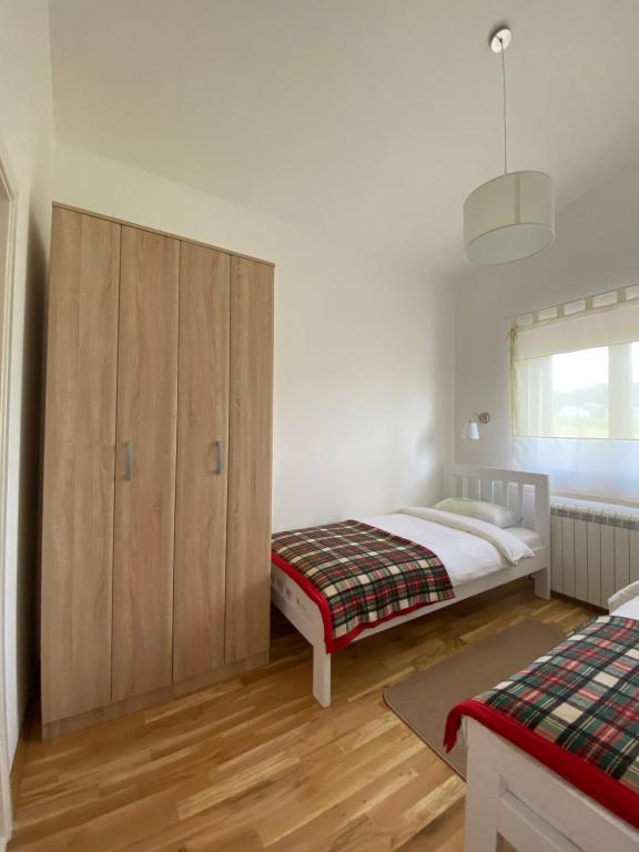 a bedroom with a bed and a wooden cabinet at Divine House in Žabljak