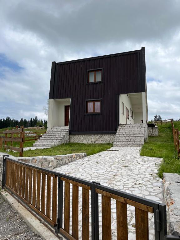 a black house with a stone walkway in front of it at Divine House in Žabljak