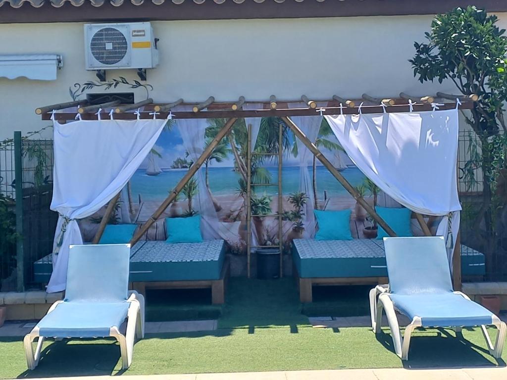 a porch with two chairs and a pergola at Residencial La Teja in Zahora