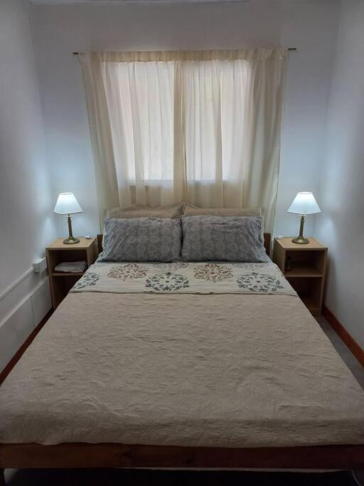 a bedroom with a large bed with two night stands at Departamento impecable. con cochera in Luján