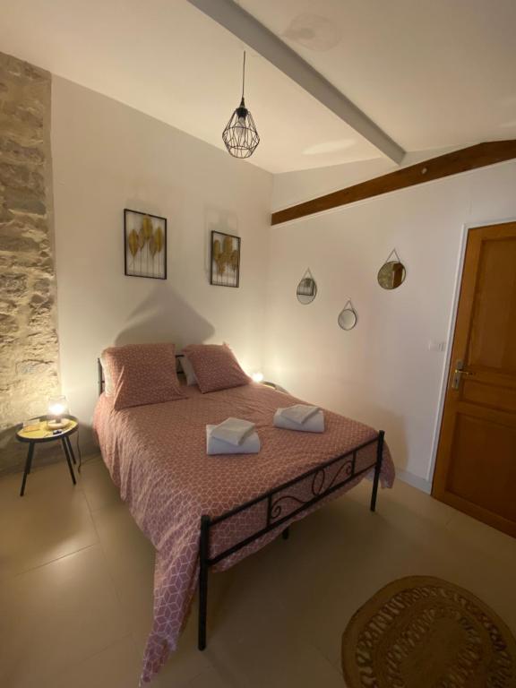 um quarto com uma cama com uma colcha rosa em Maison cosy proche centre ville em Compiègne