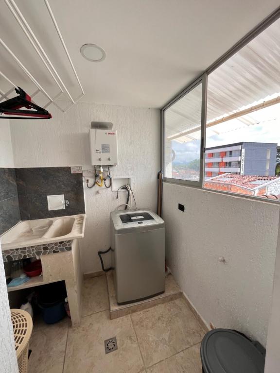 Lujoso Apartamento para Vacaciones y Negocios في كارتاغو: حمام صغير مع مغسلة وغسالة ملابس