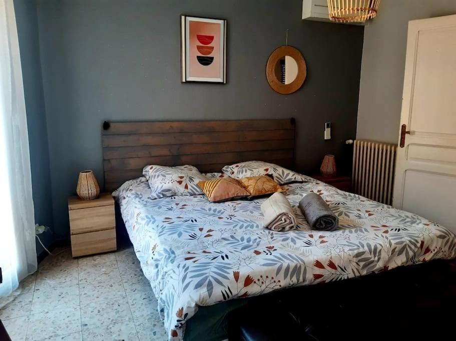 a bed with pillows on it in a bedroom at Charmante maison de ville avec jardin in Perpignan