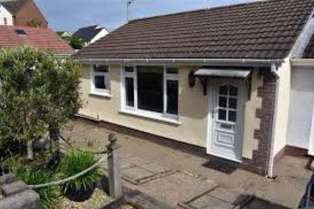 a small house with a roof at Bungalow a few minutes from the sea. in The Mumbles