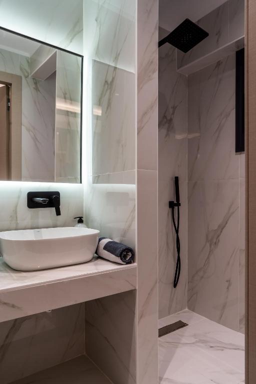 a white bathroom with a sink and a mirror at NERO SEASCAPE SUITES in Fanari