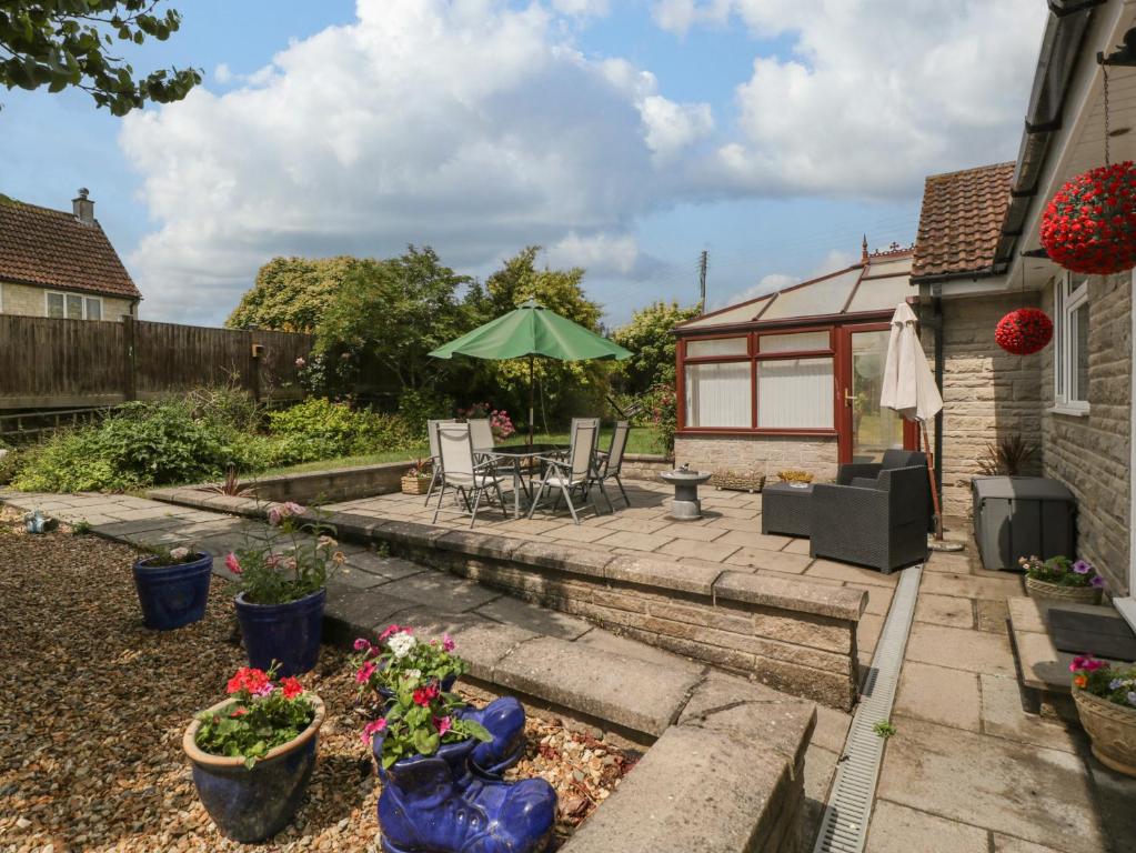 a patio with a table and chairs and an umbrella at Melita in Langport