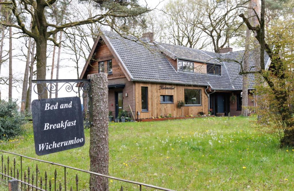 una casa con un cartel delante de ella en B&B Wicherumloo en Wekerom