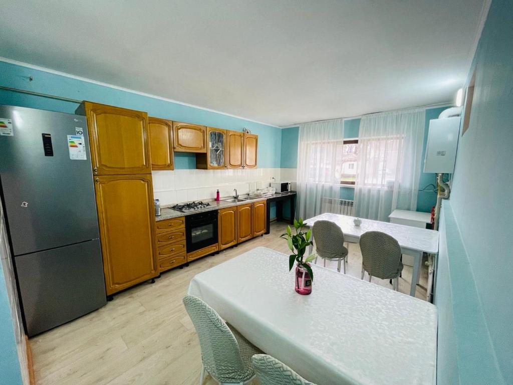 een keuken met een tafel en stoelen en een keuken met gele kasten bij Hostel Akacia in Simkent