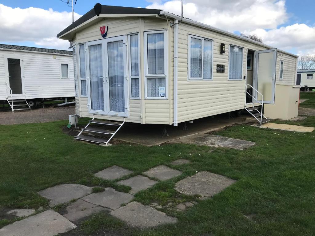 a mobile home is parked in a yard at Luxury 8 and 6 berth caravans in Jaywick Sands