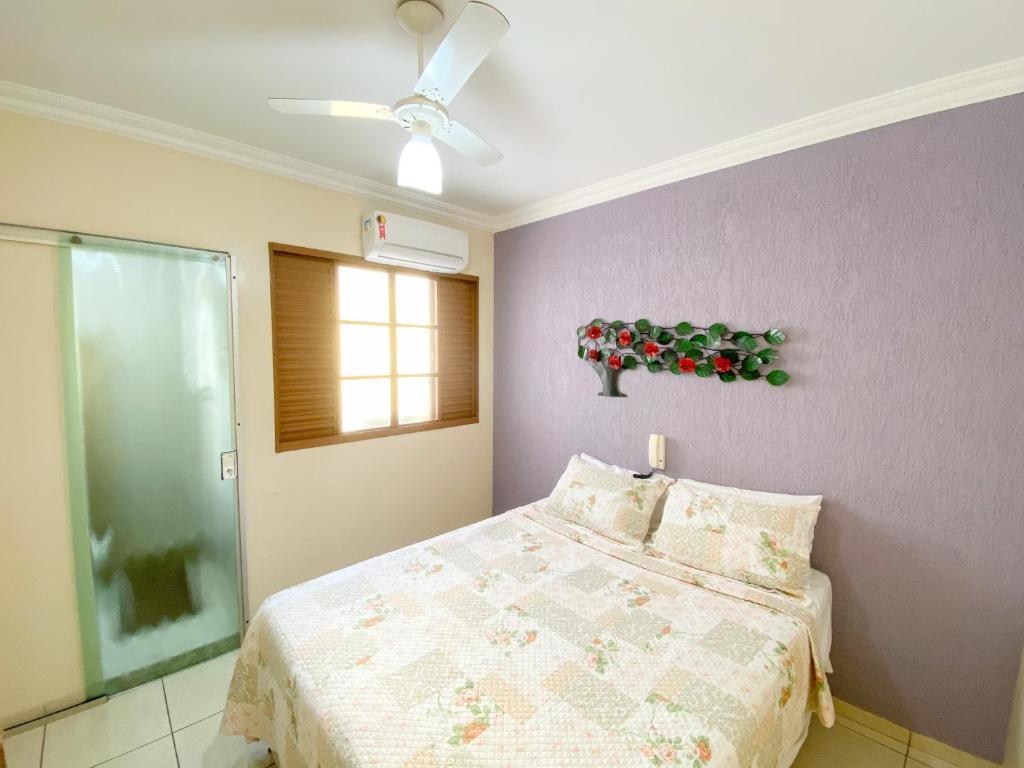 a bedroom with a bed and a ceiling fan at Elite Palace Hotel in Pará de Minas