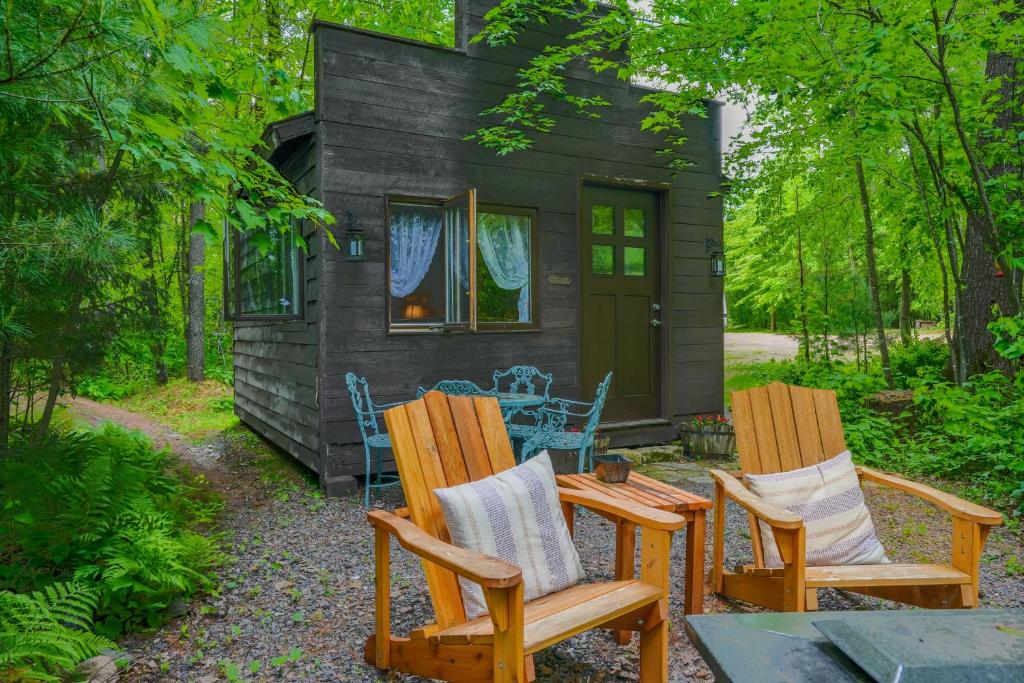 two chairs and a table in front of a tiny house at Vintage Wild West Tiny Hotel in the Woods! in Pine City