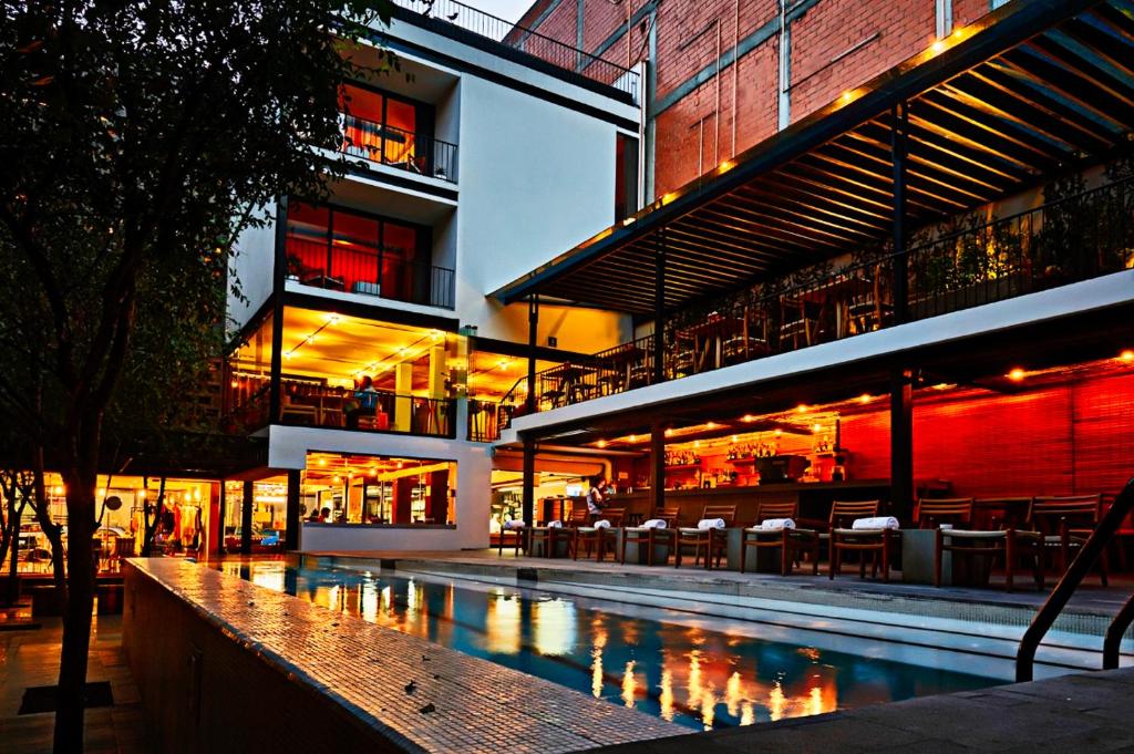 un edificio con piscina frente a un edificio en Hotel Carlota, en Ciudad de México