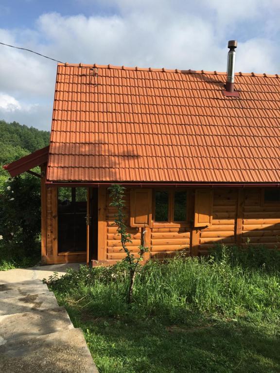 eine Holzhütte mit orangefarbenem Dach in der Unterkunft Brvnara Ruska sauna in Čajetina