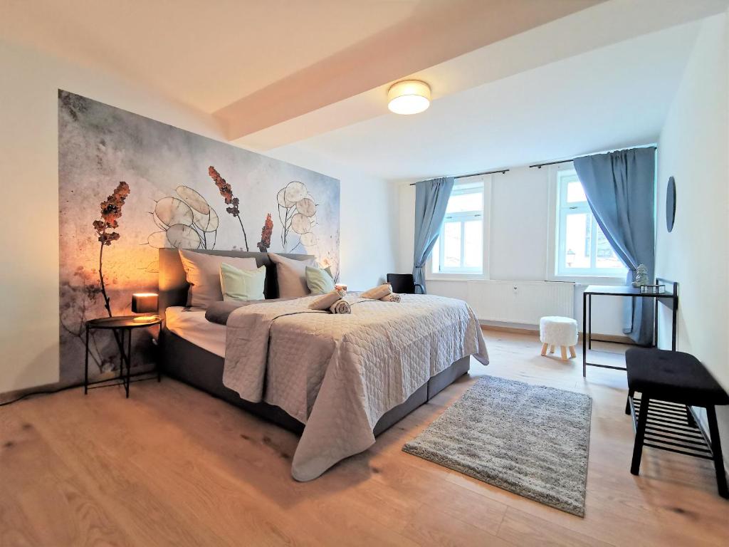 a bedroom with a bed and a painting on the wall at BohnApartments- Haus am Markt - 1 und 2 OG - 4 Schlafzimmer - Vollausstattung - WLAN - Zentrum in Ilmenau