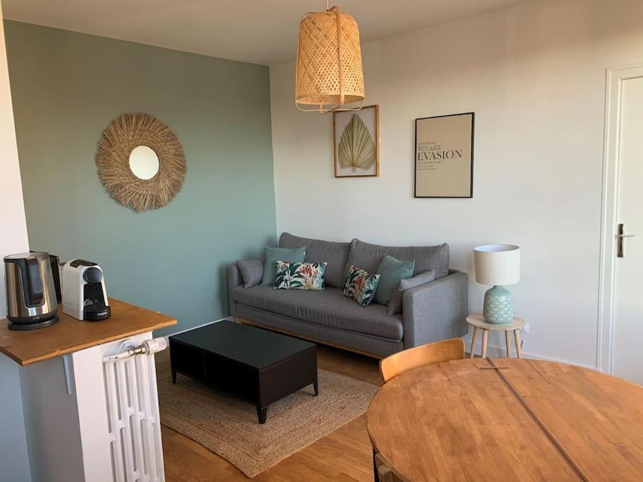 ein Wohnzimmer mit Couch und Tisch in der Unterkunft Le Chinchauvaud - Spacieux T2 - Coup de foudre garanti en face de la gare des Bénédictins in Limoges