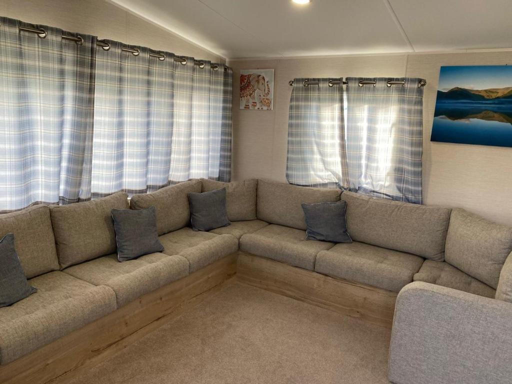 a living room with a couch and two windows at Luxury 8 and 6 berth caravans in Jaywick Sands