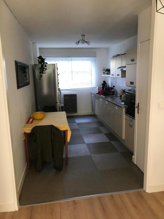 a kitchen with a table and a refrigerator at Appartement T2 Manoir de Malville in Nantes