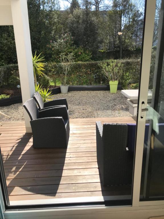 an open door with two chairs on a patio at Appartement T2 Manoir de Malville in Nantes
