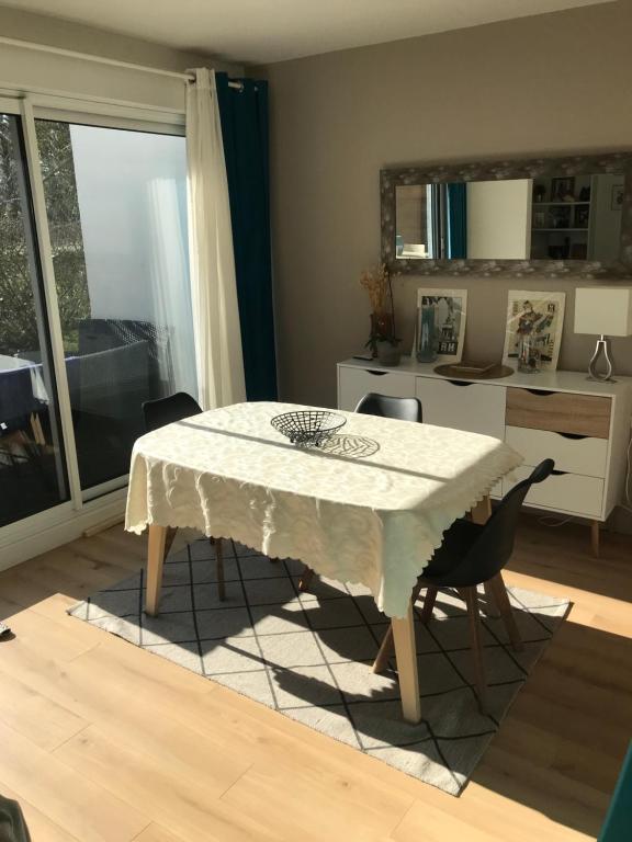 a dining room with a white table and chairs at Appartement T2 Manoir de Malville in Nantes