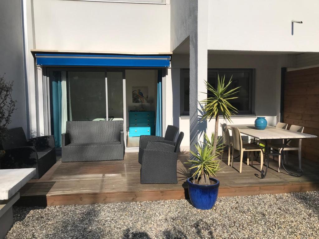 une terrasse avec une table et des chaises dans une maison dans l'établissement T 2 terrasse sud Manoir de Malville, à Nantes