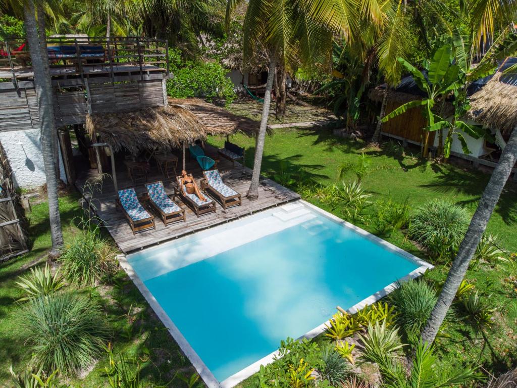 uma vista sobre uma piscina com cadeiras e uma casa em Vila do Junco em Santo Amaro