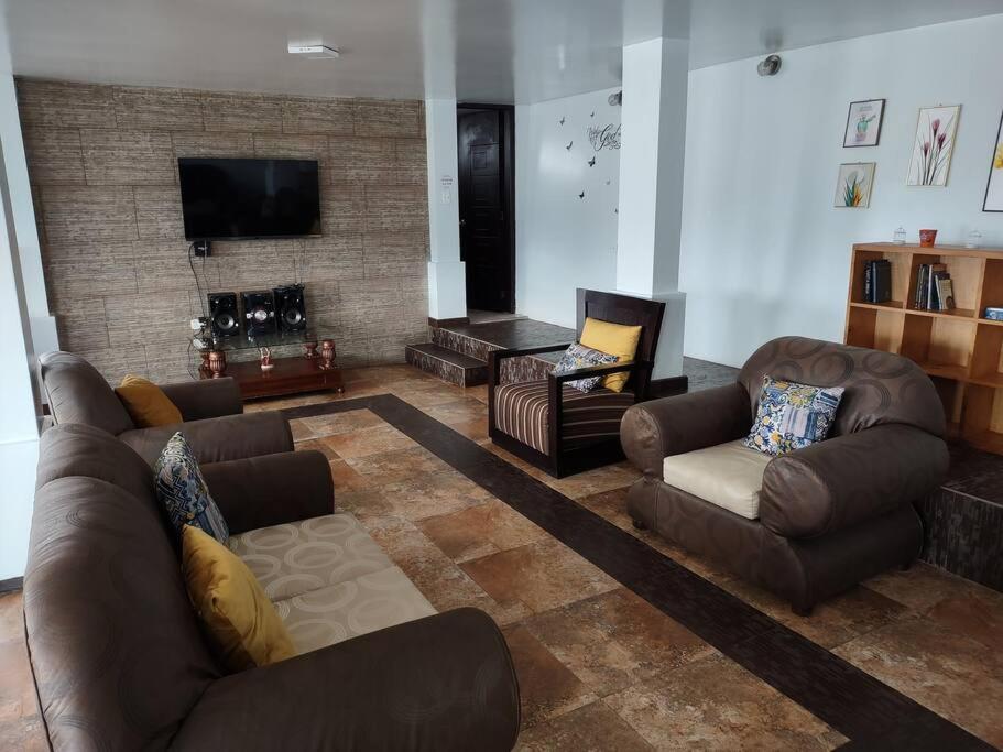 sala de estar con muebles de cuero y chimenea en Espectacular Casa Vacacional !Sorprendente vista!, en Ambato