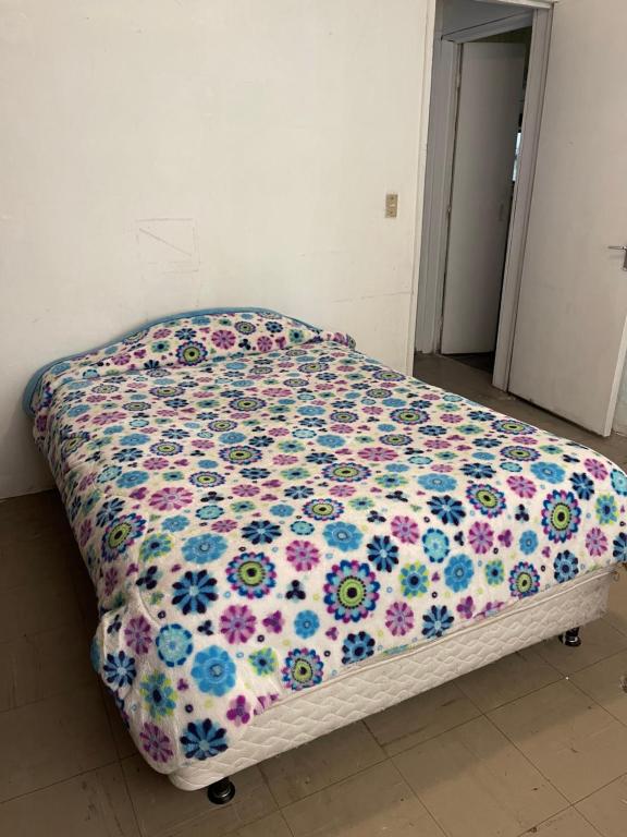 een bed met een bloemdekbed in een slaapkamer bij Casa H236 in Mexico-Stad