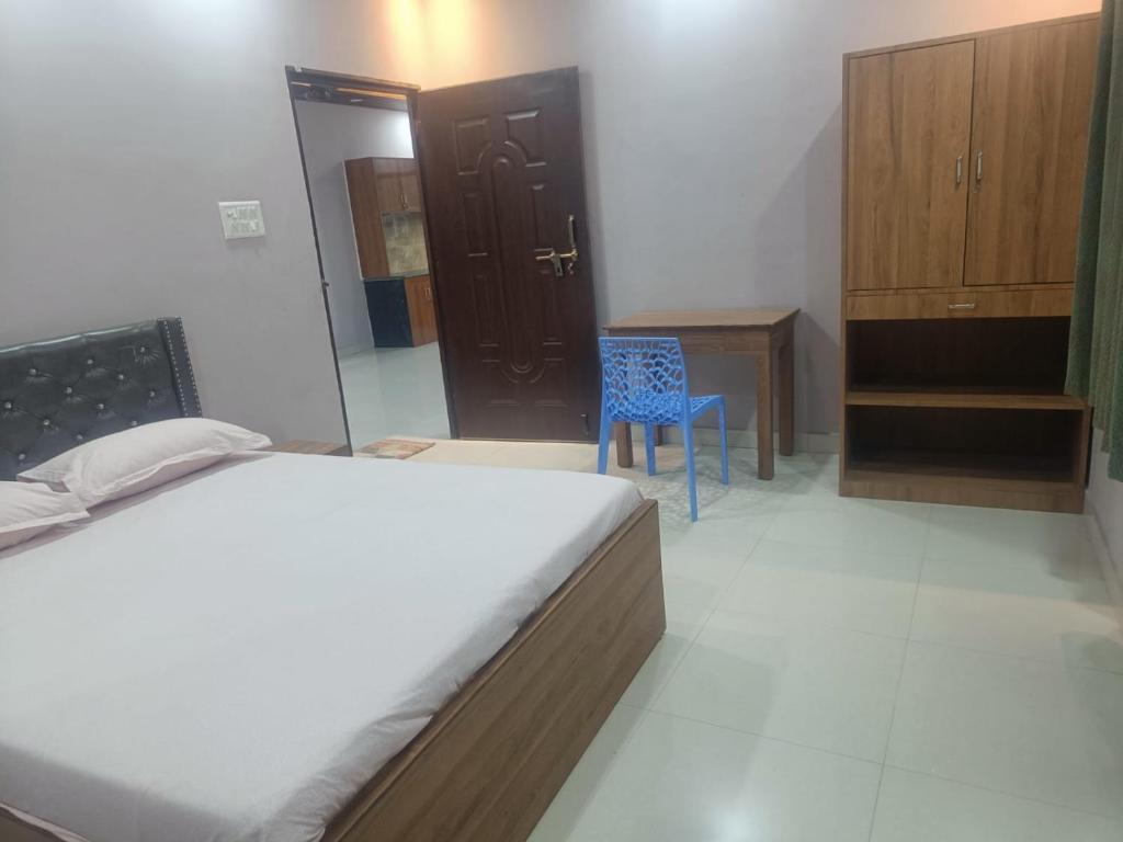 1 dormitorio con 1 cama y 1 silla azul en Rangili Baag, en Varanasi