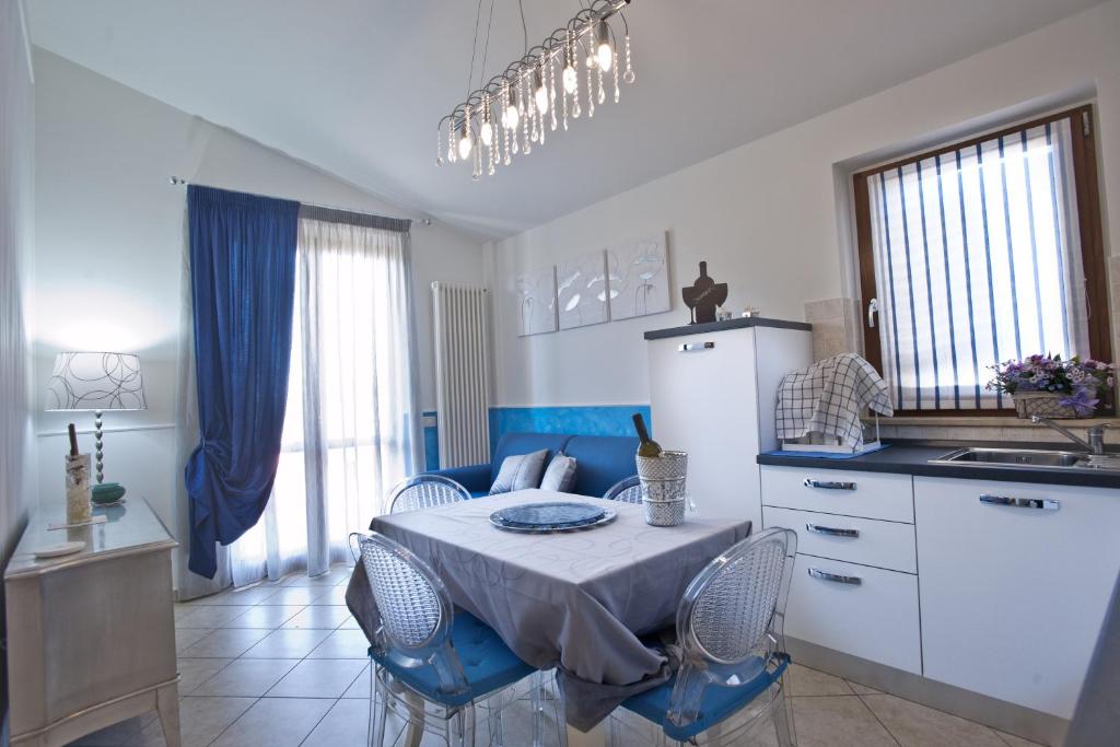 uma cozinha com uma mesa e cadeiras numa cozinha em Casavacanze Azzurro Mare em Porto SantʼElpidio