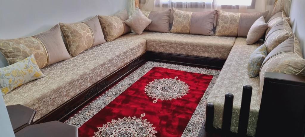 a brown couch with a red rug in a living room at Résidence Toudert jiji in Agadir