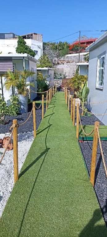 a grass pathway with wooden posts and a fence at Asociación deportiva TAGOROR LOS OLIVITOS in Adeje