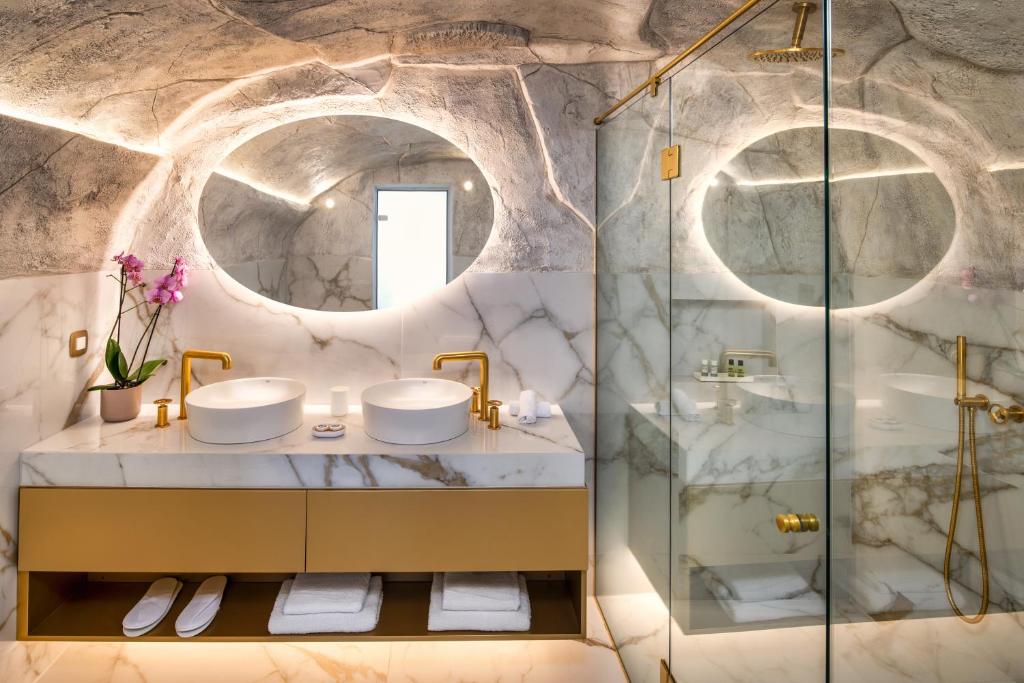 łazienka z 2 umywalkami i prysznicem w obiekcie Aura Suites w mieście Firostefani