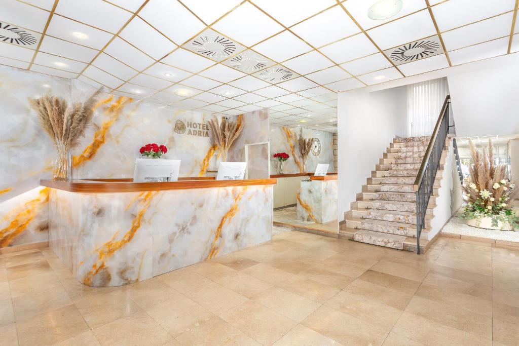 vestíbulo con encimera de mármol y escaleras en Hotel Adria, en Malinska