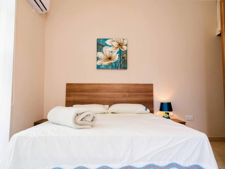a bedroom with a large bed with white sheets at Sea views apartment-wifi-sleep 5 in Marsaskala