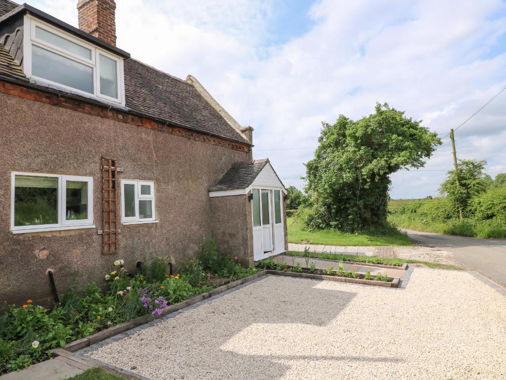 a house with a gravel driveway in front of it at Tolldish Cottage in Stafford